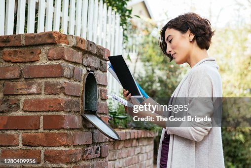 Side view of beautiful young woman at mailbox Side view of beautiful young woman at mailbox