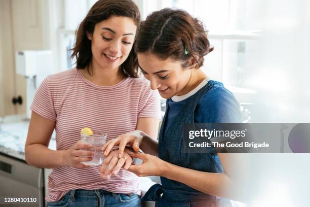 smiling woman looking at engagement ring in kitchen - man proposing indoor stock-fotos und bilder