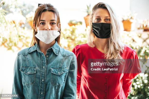 friends posing looking at camera with protective face mask - covering nose stock pictures, royalty-free photos & images