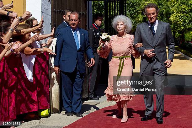 Spain's Duchess of Alba, Maria del Rosario Cayetana Fitz-James-Stuart and her husband Alfonso Diez walk towards photographers after their wedding...