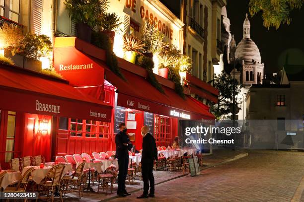 Servers wait for customers in front of an empty terrace at place du Tertre on the Butte Montmartre on October 15, 2020 in Paris, France. In the...