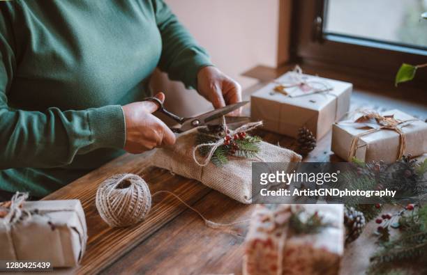 woman decorating christmas gifts. - green belt fashion item stock pictures, royalty-free photos & images