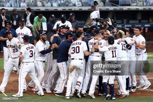 Carlos Correa of the Houston Astros is congratulated by teammates after hitting a walk off home run to win 4-3 against Tampa Bay Rays in Game Five of...