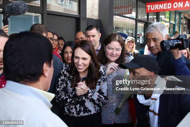 New Zealand Prime Minister Jacinda Ardern, watched by Dawit Arshak , thanks Iraqi refugee and artist Abdelkhalik Rahm El Fatlawi for a portrait of...