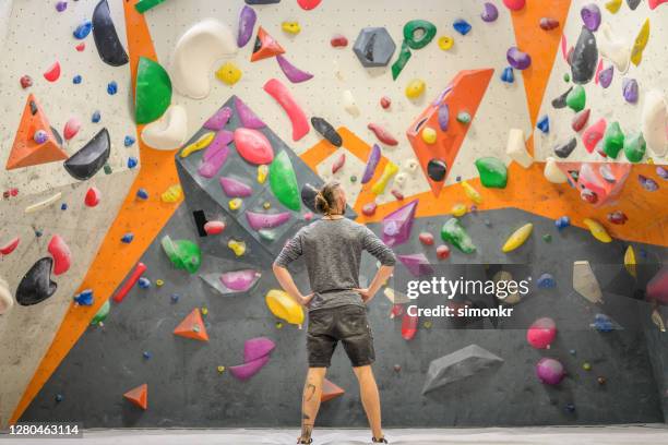 mann steht in indoor-kletterhalle - climbing plant stock-fotos und bilder