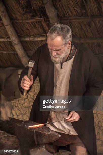 een individuele vikingsmid in een vikingnederzetting - smid stockfoto's en -beelden