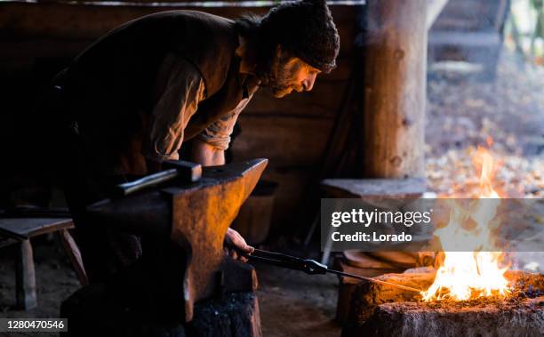 un singolo fabbro vichingo in un insediamento vichingo - fabbro ferraio foto e immagini stock