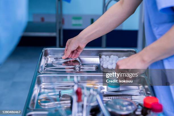 doctor preparing surgical instruments - equipamento cirúrgico imagens e fotografias de stock