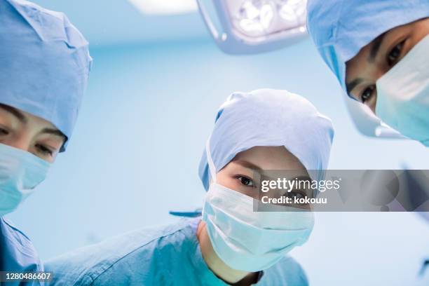 surgeons face to face on the operating table - orthopedic surgeon stock pictures, royalty-free photos & images