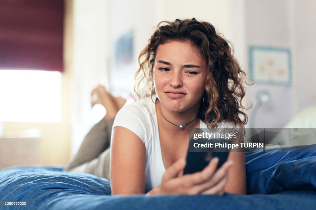 Teenage girl and everyday life. In bed with smartphone