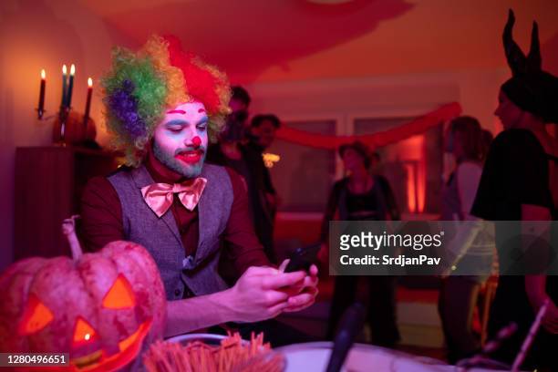 smiling young man sitting and texting on a phone at the halloween party - period costume stock pictures, royalty-free photos & images