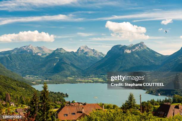 france, savoie, annecy, panoramic view of the lake flown over by paragliders - annecy stockfoto's en -beelden