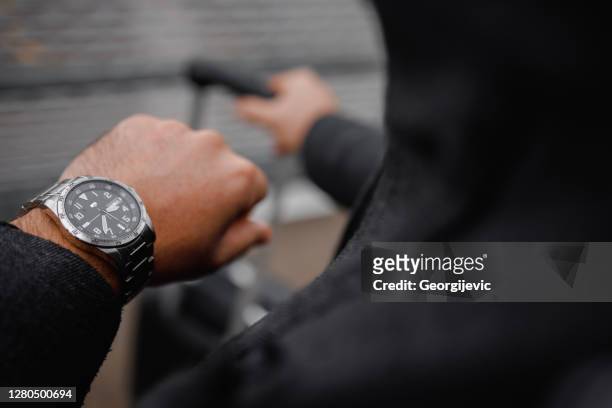 sluit omhoog van onherkenbare mens die de tijd op zijn horloge controleert. - wristwatch stockfoto's en -beelden