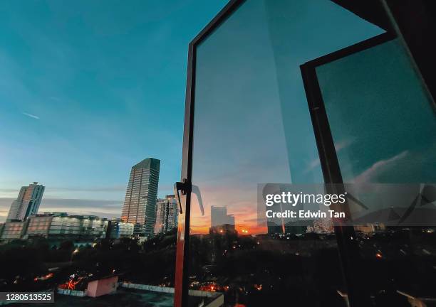 solnedgång tittar genom fönster på city med reflektion på fönster med solnedgångssol - open city bildbanksfoton och bilder