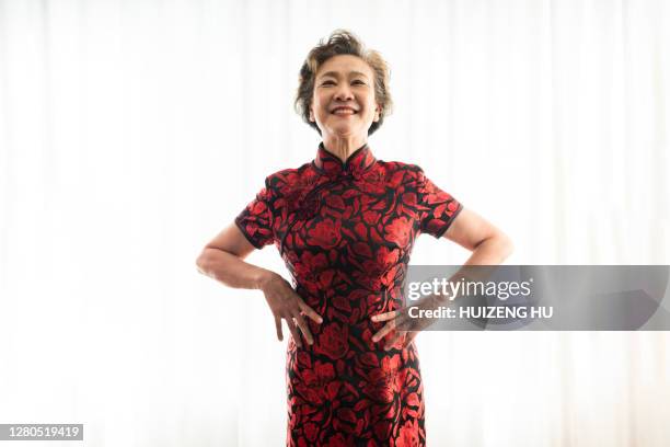 senior woman in cheongsam.  happy senior woman smiling at camera. - abito tradizionale cinese foto e immagini stock