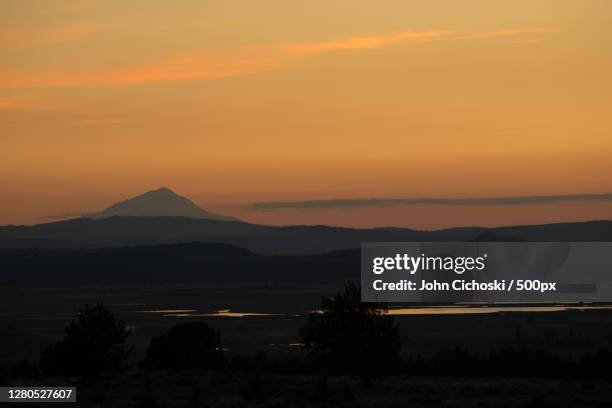 scenic view of silhouette of mountains against orange sky,modoc county,california,united states,usa - modoc county california stock pictures, royalty-free photos & images