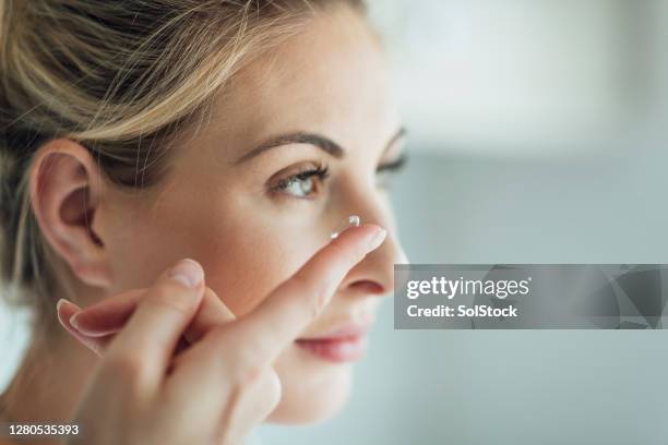 putting in a contact lens - inserts stock pictures, royalty-free photos & images