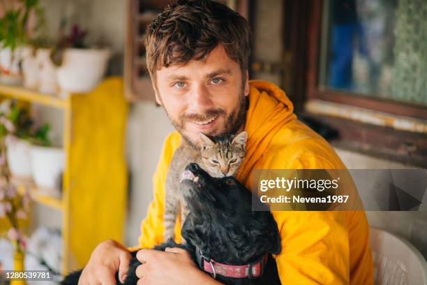 man cuddling with his cat and his dog - hugging a chair stock pictures, royalty-free photos & images