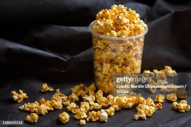 close-up of corn kernels in bowl on table - caramel popcorn stock pictures, royalty-free photos & images