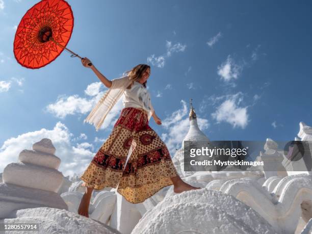 vrouw die op oude tempel in myanmar springt - myanmar culture stockfoto's en -beelden
