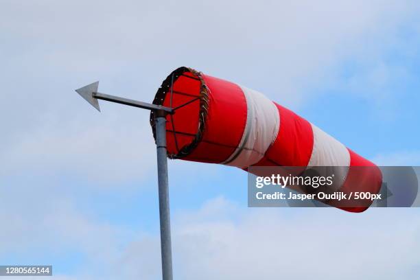 low angle view of red flag against sky,kampen,netherlands - windsock stock pictures, royalty-free photos & images