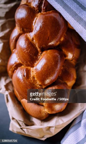 high angle view of breads in basket on table - geflochtenes brot stock-fotos und bilder