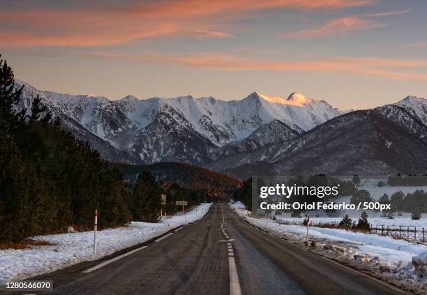 empty road leading towards snowcapped mountains against sky during sunset,les angles,france - les angles fotografías e imágenes de stock