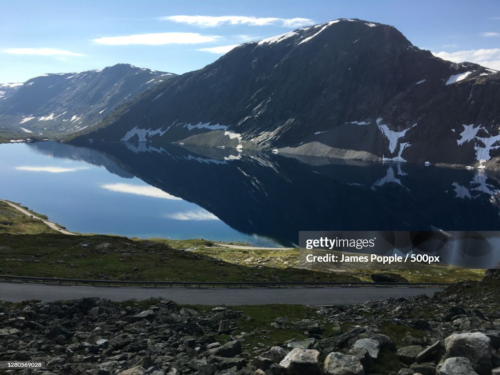 Scenic view of lake by snowcapped mountains against sky, Nibbevegen, Geiranger, Norway