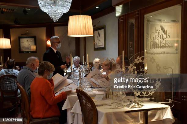 Waiters, wearing face mask, serve customers on October 1, 2020 in Narbonne, France. Les Grands Buffets restaurant, founded in 1989 by Louis Privat,...