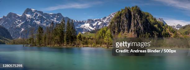 scenic view of lake by snowcapped mountains against sky - bergsee stock-fotos und bilder