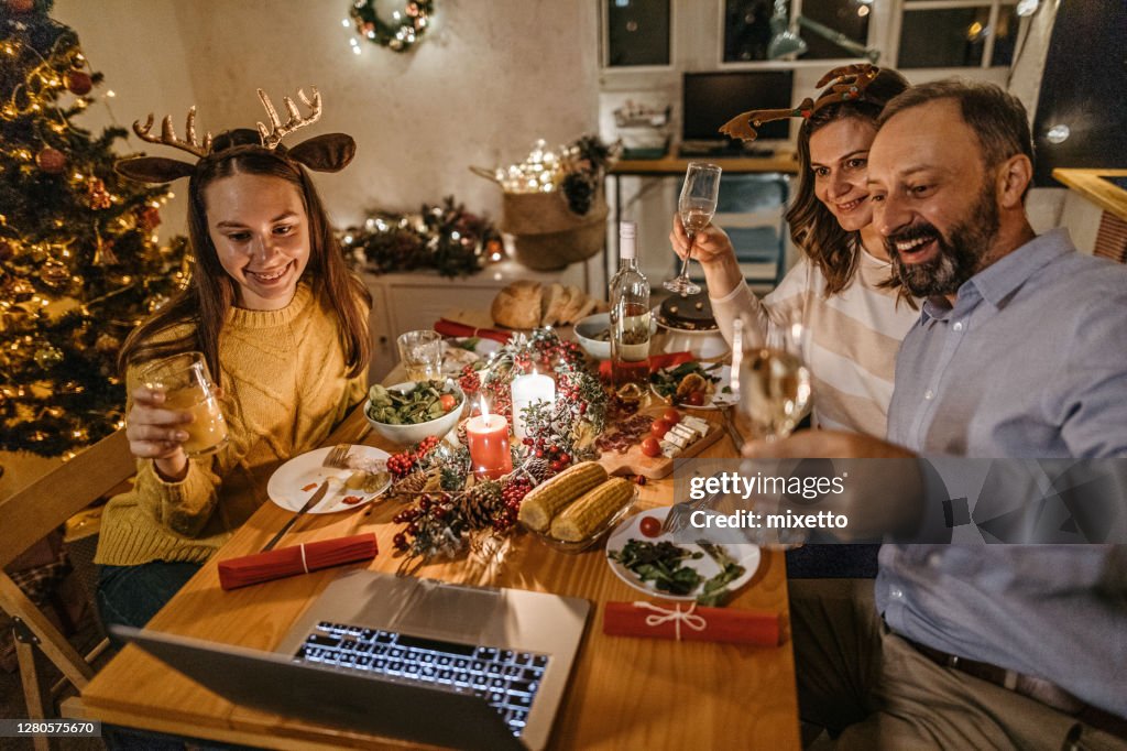 Family toasting on video call with near and dear ones on occasion of Christmas celebration