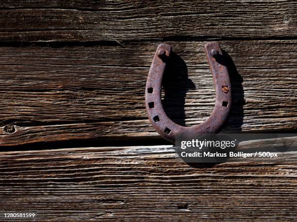 close-up of rusty metallic horseshoe on wooden table,switzerland - hufeisen - fotografias e filmes do acervo