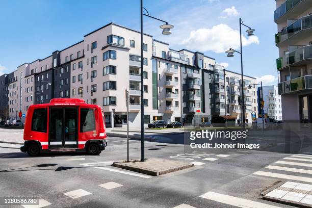 bus on road, blocks of flats on background - autonomous stock-fotos und bilder