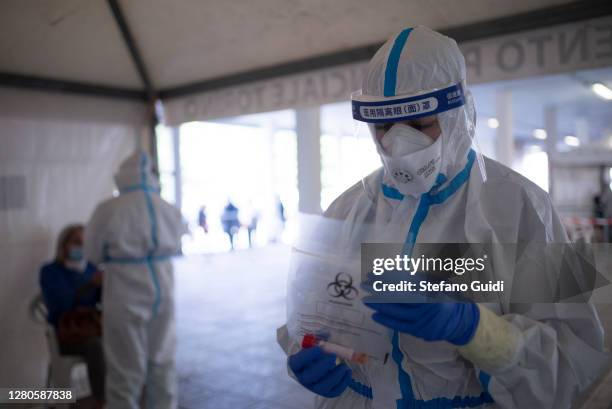 Medical staff in full PPE conducts swab tests on man in a hotspot for Covid-19 in Via Negarville on October 16, 2020 in Turin, Italy. A new hotspot...