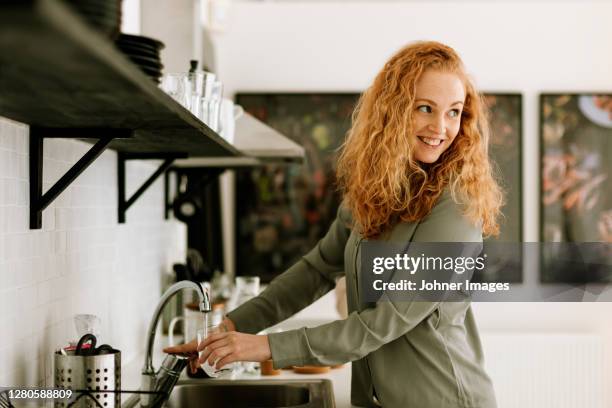 smiling woman in office kitchen - dirty dishes ストックフォトと画像