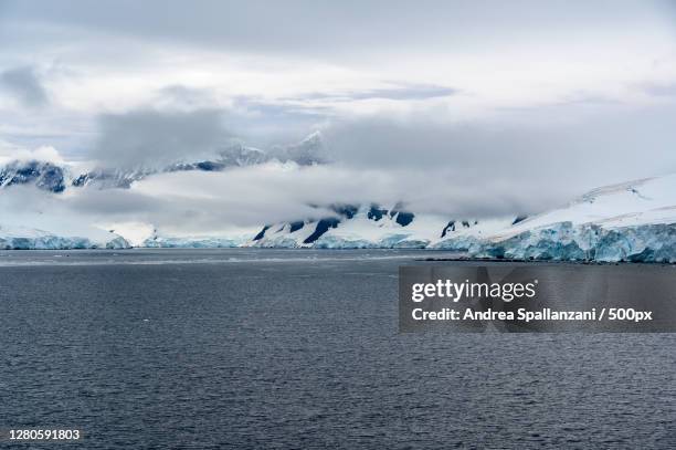 scenic view of sea against sky during winter, antarctica - ghiacciai stockfoto's en -beelden