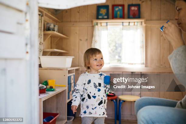 toddler girl in playhouse playing tea party with mother - playhouse stock pictures, royalty-free photos & images