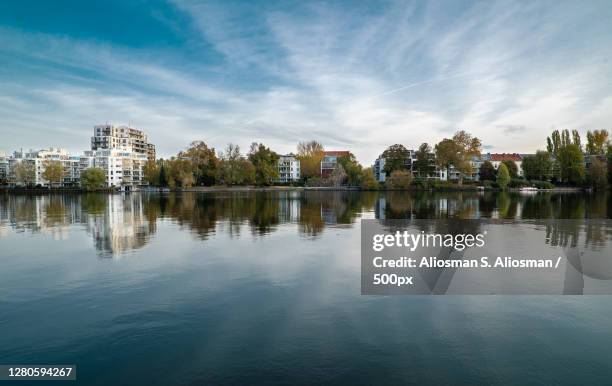 scenic view of lake by buildings against sky, treptower park, germany - treptower park stock pictures, royalty-free photos & images