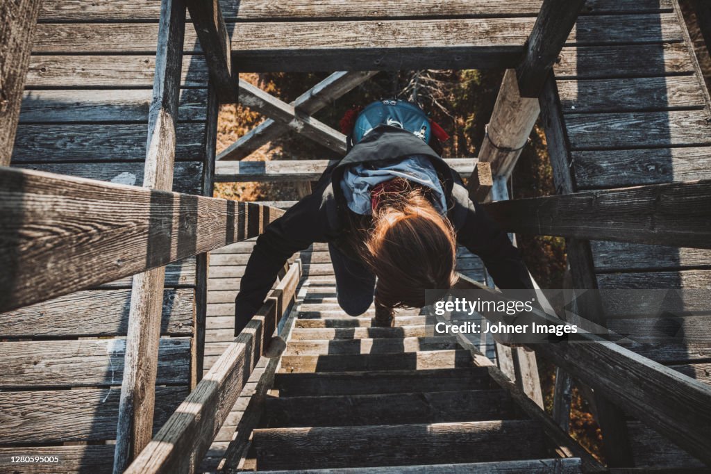 Female hiker climbing lookout tower