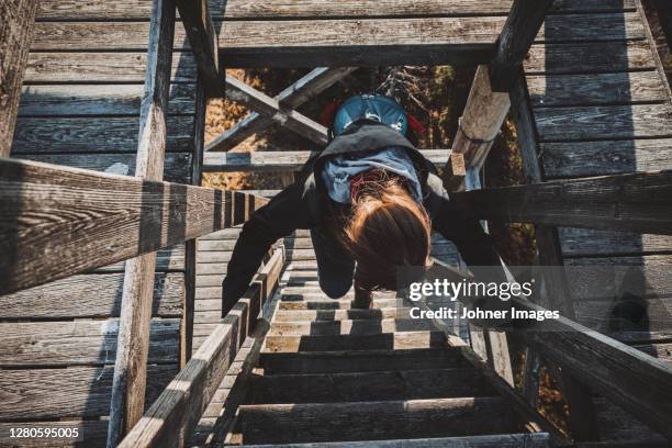 Female Hiker Climbing Lookout Tower High-Res Stock Photo