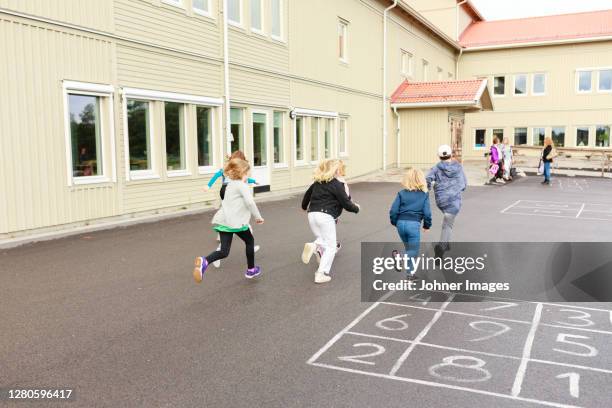 children running on schoolyard - school yard stock pictures, royalty-free photos & images