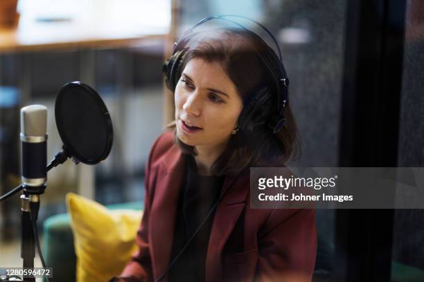 woman broadcasting from radio station - journalist stock-fotos und bilder