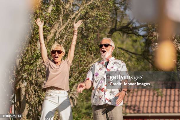 happy senior couple in garden - couple in surprise stock pictures, royalty-free photos & images