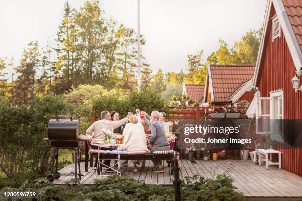 family having meal in garden - summer solstice photos et images de collection