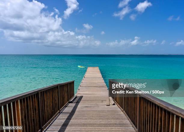 empty wooden pier on sea against sky, sint maarten, sint maarten dutch part - saint martin caraibi stock-fotos und bilder