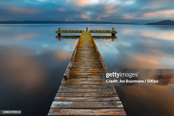 scenic view of pier over sea against sky during sunset, kawaha point, rotorua, new zealand - lake rotorua bildbanksfoton och bilder