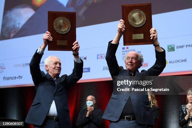 Luc Dardenne and Jean-Pierre Dardenne hold their "Prix Lumiere" over head during the tribute to the brothers Jean-Pierre Dardenne and Luc Dardenne at...