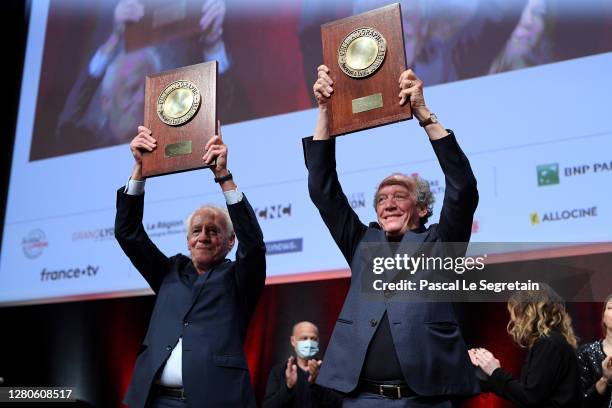 Luc Dardenne and Jean-Pierre Dardenne hold their "Prix Lumiere" over head during the tribute to the brothers Jean-Pierre Dardenne and Luc Dardenne at...