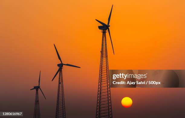 low angle view of silhouette of windmills against sky during sunset,jodhpur,rajasthan,india - renewable energy india stock pictures, royalty-free photos & images