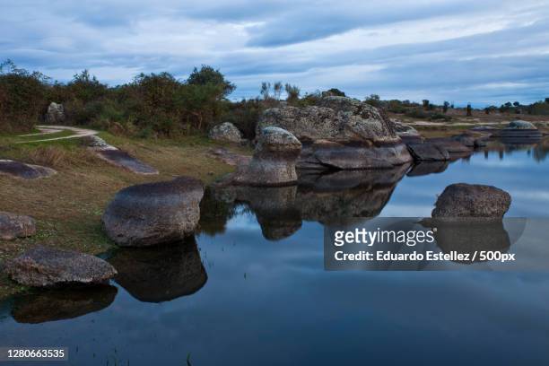 scenic view of rocks in lake against sky,extremadura,spain - geologia stockfoto's en -beelden